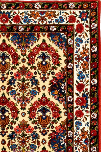 "Royal Garden Bakhtiari" rug with an ivory background, floral motifs in vibrant colors, and a deep red border, showcasing Persian craftsmanship.