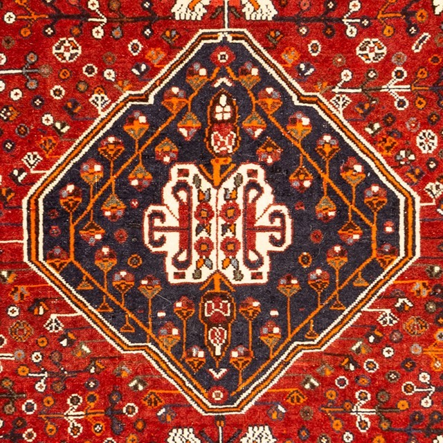 Image of an antique Persian handwoven rug with geometric and floral patterns.